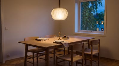 Pendel som henger 65 cm over et eikespisebord om kvelden, med et varmt lys som samler seg over bordet