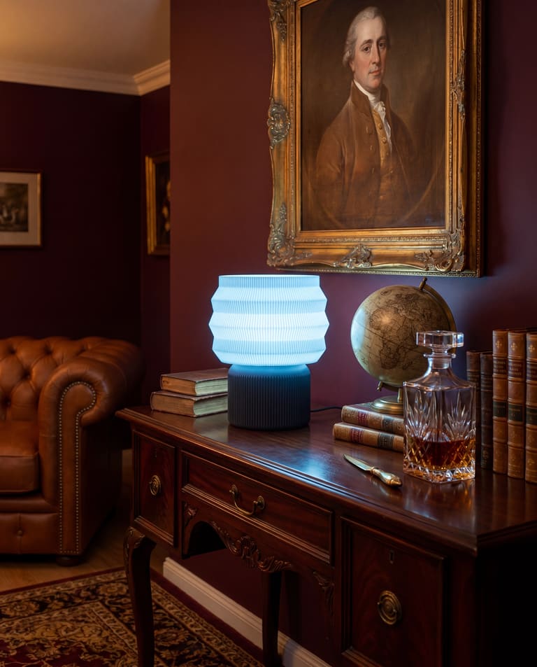 LEAH-lampe i et eklektisk interiør med dyp grønn og dyp rød vegg, vintage-møbler og kunstplakater